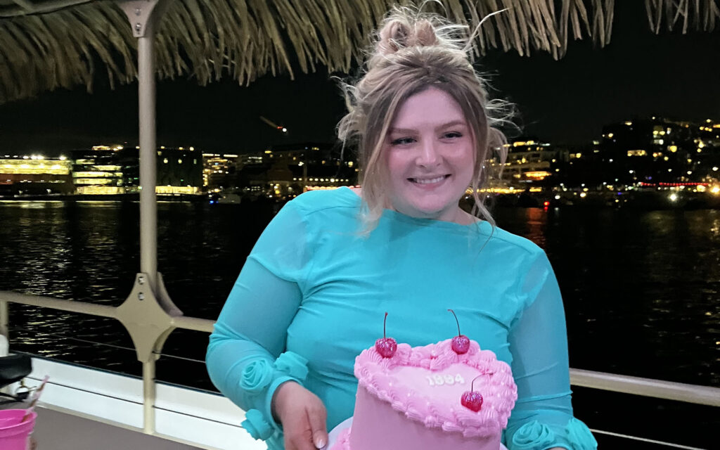 Birthday girl posing with cake on a birthday party boat rental in Washington DC.