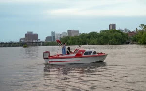 Small red vintage boat cruising the James River near Richmond Virginia. Retro Boat Rentals RVA by Sea Suite Cruises.