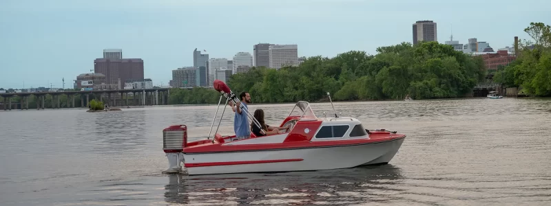 Small red vintage boat cruising the James River near Richmond Virginia. Retro Boat Rentals RVA by Sea Suite Cruises.